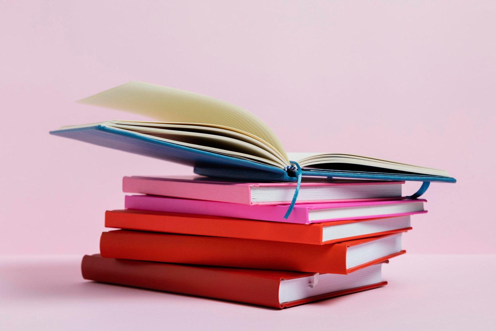 arrangement with books pink background